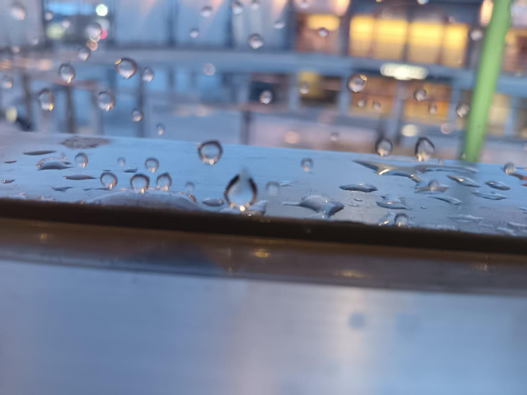 摄影作品《雨落剧场》：隔着缀满水珠的玻璃望向剧场朦胧的灯火